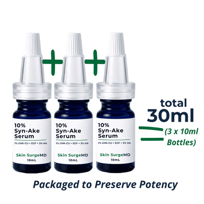 Three 10mL bottles of Skin SurgeMD 10% Syn-Ake Serum shown in a pack of three, with green plus signs indicating a total of 30ml bottles. The bottles are dark blue glass with white caps and white labels.