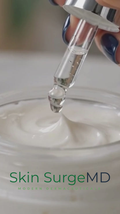 Close-up of Skin SurgeMD Argireline Peptide Booster Concentrate being added to a white face cream with a dropper, demonstrating how to customize skincare with a concentrated anti-aging peptide booster.